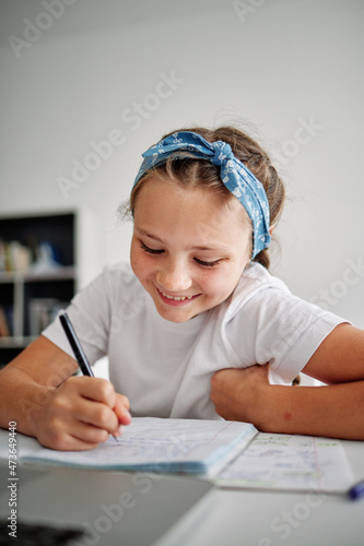 Cheerful girl writing essay  photo