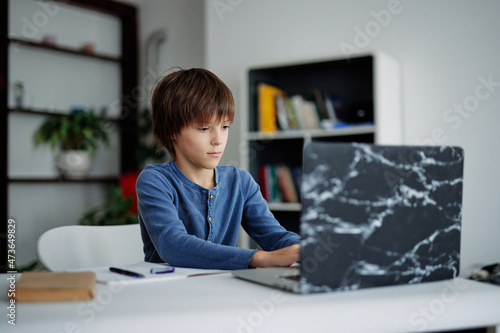 Young boy using laptop during online education process