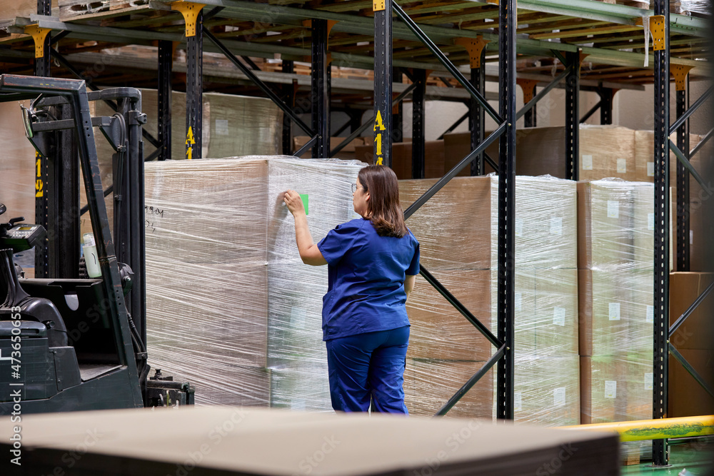 Worker labeling boxes in storehouse Worker labeling boxes in storehouse
