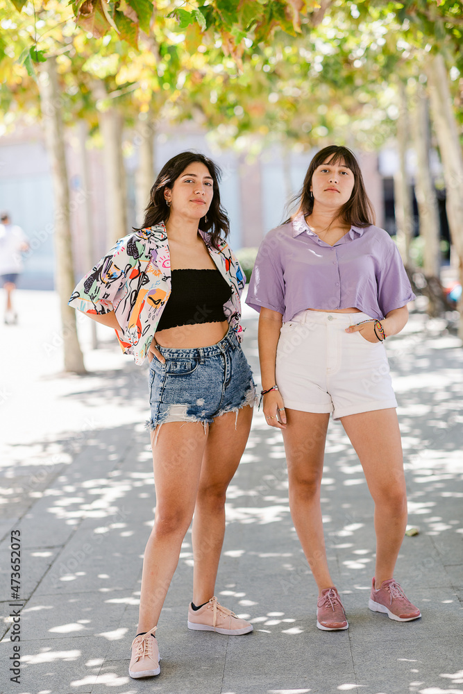 Teenage sisters posing at camera at park Teenage sisters posing at camera at park