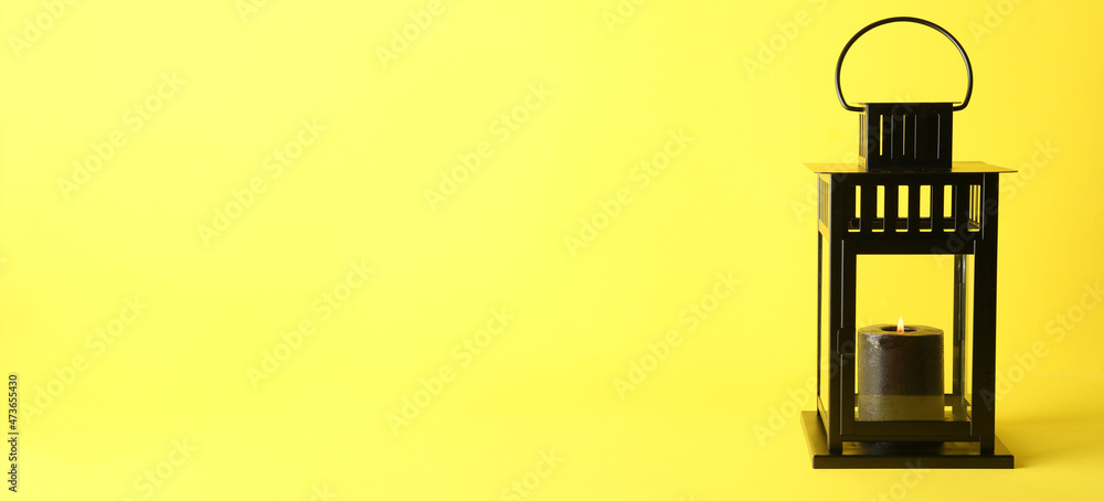 Beautiful Christmas lantern with burning candle on yellow background with space for text Beautiful Christmas lantern with burning candle on yellow background with space for text