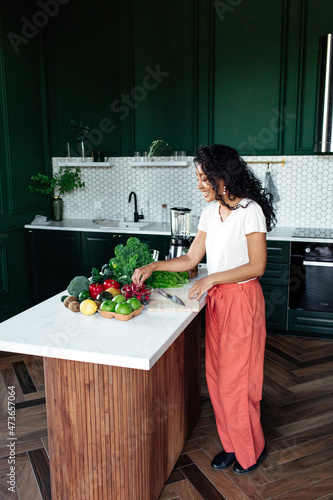 Black woman at kitchen island with vegetables photo