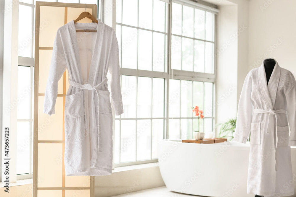 Obraz premium Bathrobes in interior of stylish bathroom with window