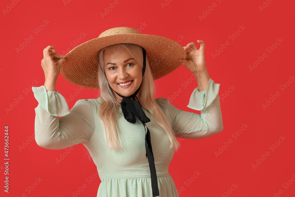 Happy woman wearing straw hat on red background Happy woman wearing straw hat on red background