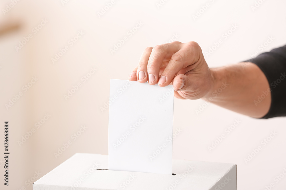 Voting young man near ballot box Voting young man near ballot box