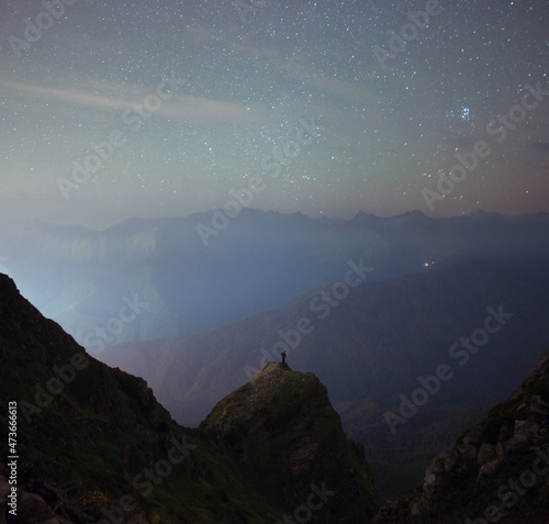 Wanderer on the rock under night sky photo