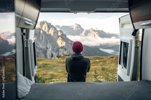 Man infront of camper looking into the Mountains