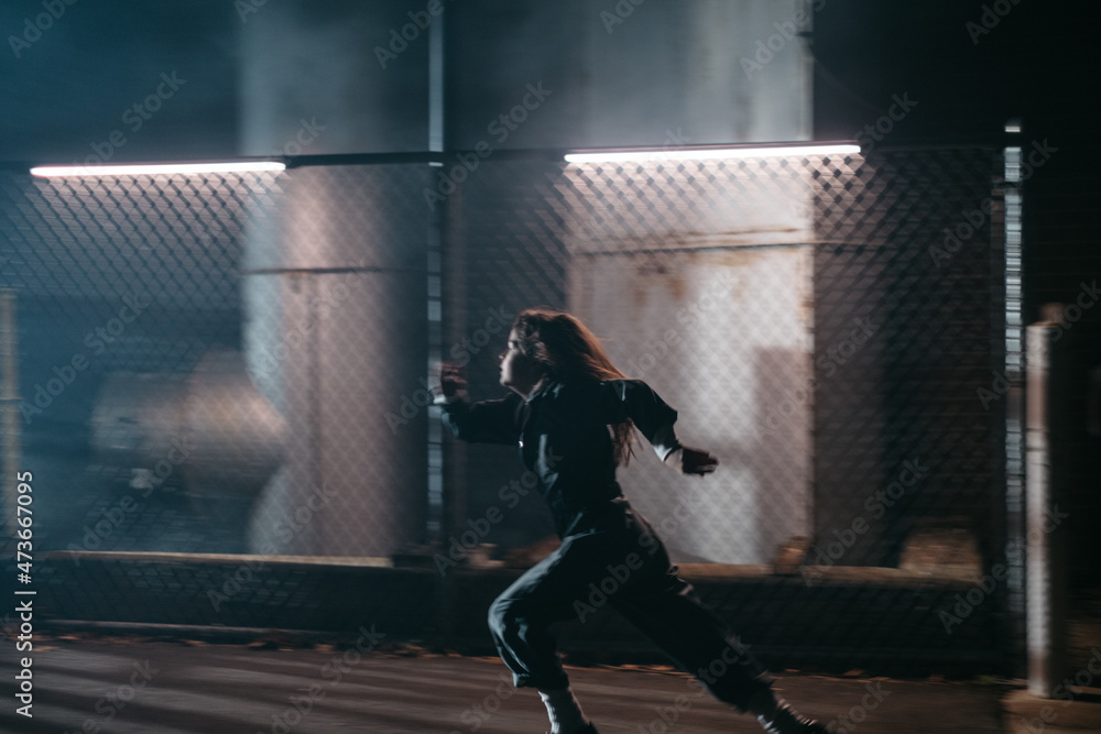 Young girl runs in an industrial area Young girl runs in an industrial area