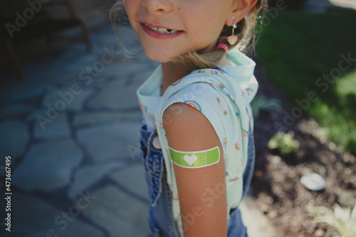 Young girl shows off bandaid from her vaccine shot photo