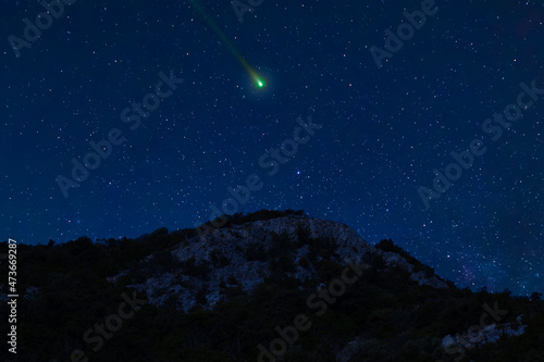 Night scene with a comet, an asteroid, a meteorite flying in the sky. Night landscape.