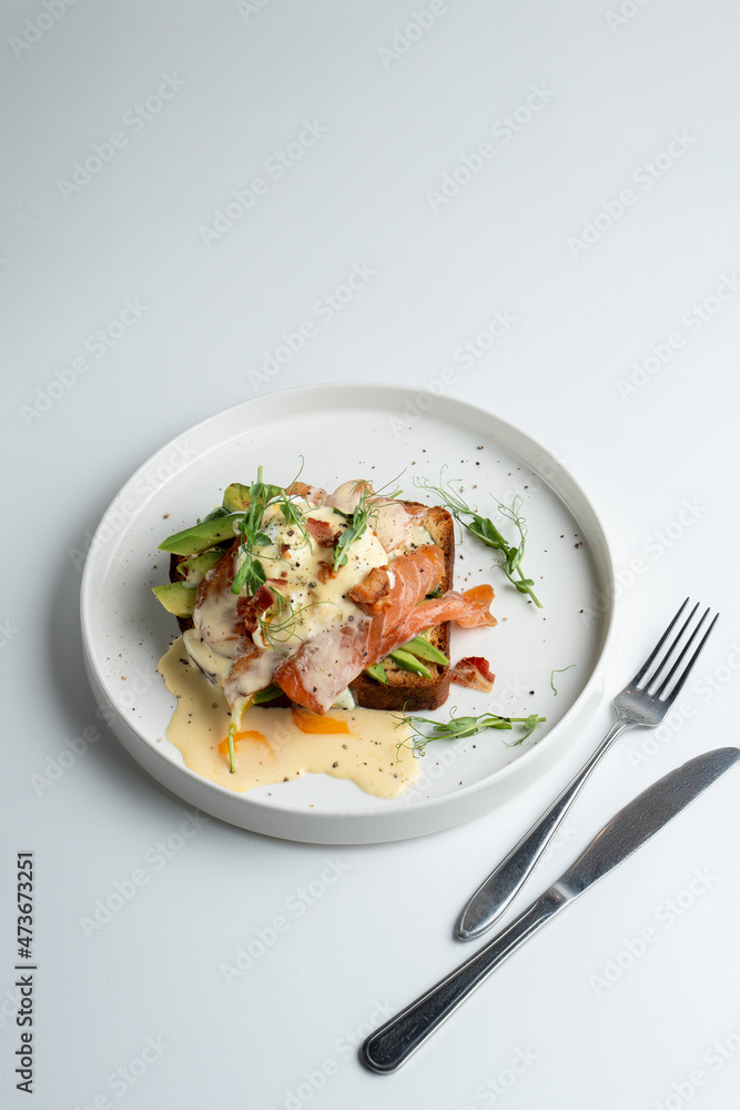 California healthy breakfast in a trendy coffee house, salmon and poached egg song with, white minimalistic photo California healthy breakfast in a trendy coffee house, salmon and poached egg song with, white minimalistic photo