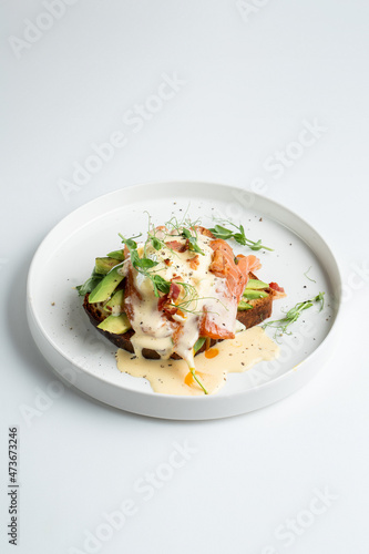French toast with lettuce and salted salmon, top view on white dish