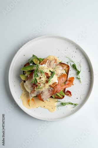 Very yummy and appetizing salmon sandwich on sweet brioche with hollandaise sauce, top view, menu photo