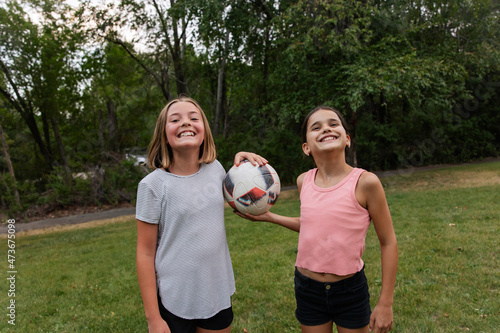 Two girls holding soccer ball photo