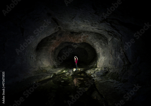 Standing woman inside a cave photo