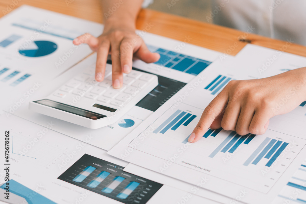 businessman or accountant hand working on calculator to calculate business data, accounting document and laptop computer at office, business concept businessman or accountant hand working on calculator to calculate business data, accounting document and laptop computer at office, business concept