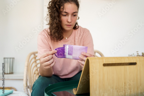 Teenager opening female condom