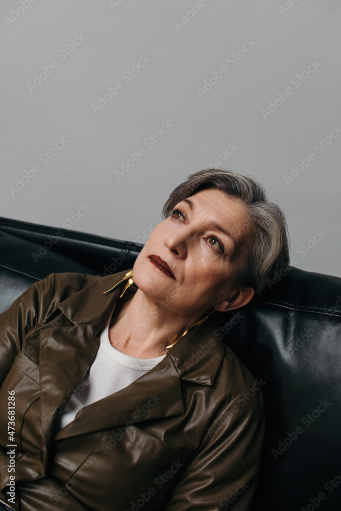 Sad senior woman on leather sofa Sad senior woman on leather sofa
