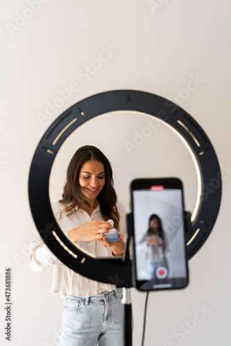 Young woman recording video blog at home photo