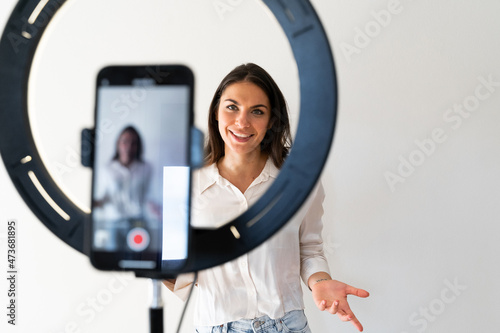 Young woman recording video blog at home photo