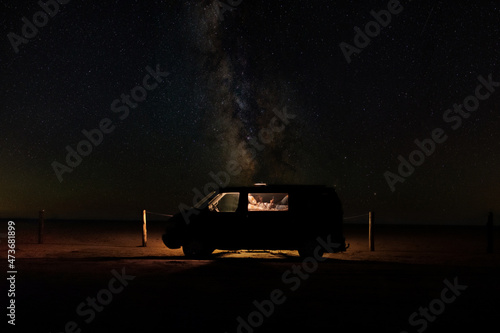 Woman inside camper at starry night photo