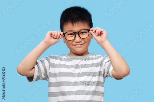 Kid wearing glasses and tshirt  taking eyesight test
