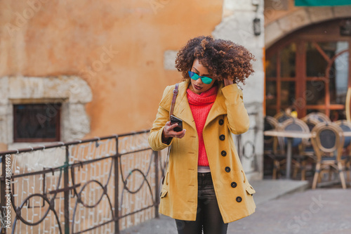  woman with mobile phone walking in the city photo