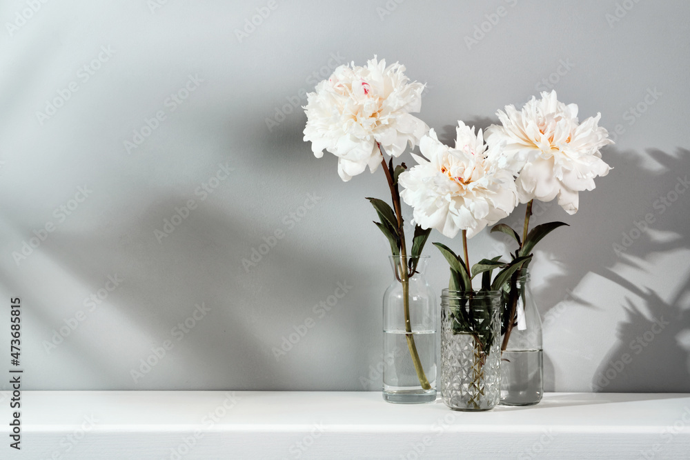 Elegant white peonies flowers arrangement on table wall background. Template for text or artwork, trendy shadows Elegant white peonies flowers arrangement on table wall background. Template for text or artwork, trendy shadows