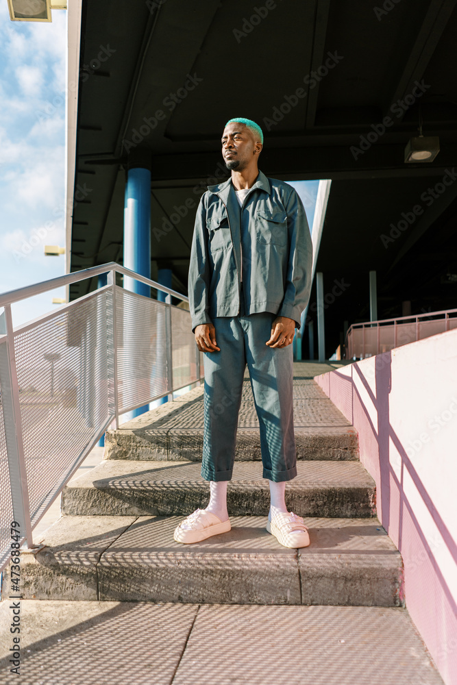 Black man standing on stairway in shadow Black man standing on stairway in shadow