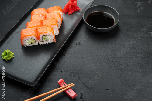 Fresh philadelphia sushi roll served on black plate