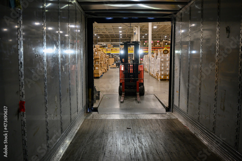 Man Loading tractor trailer truck at warehouse 
