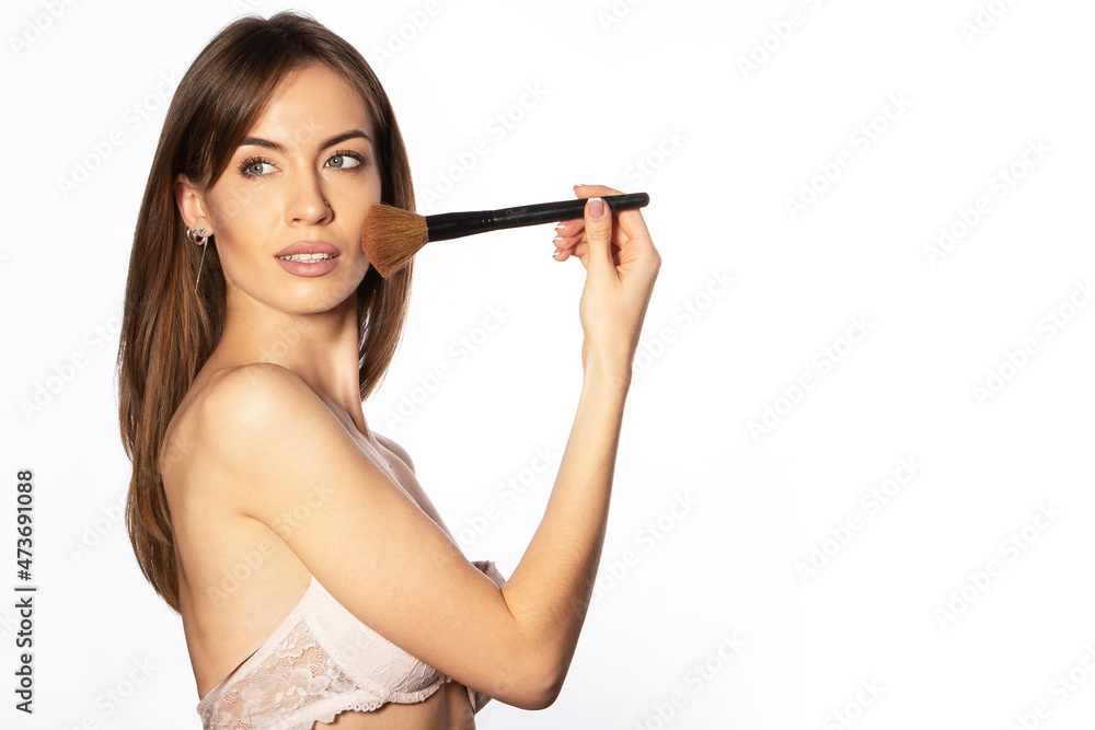 Nude makeup. The girl applies powder to her face with a blush brush. Nude makeup. The girl applies powder to her face with a blush brush.