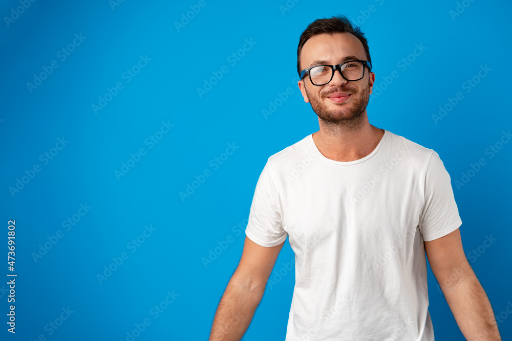 Portrait of smiling handsome guy in white t-shirt over blue background Portrait of smiling handsome guy in white t-shirt over blue background
