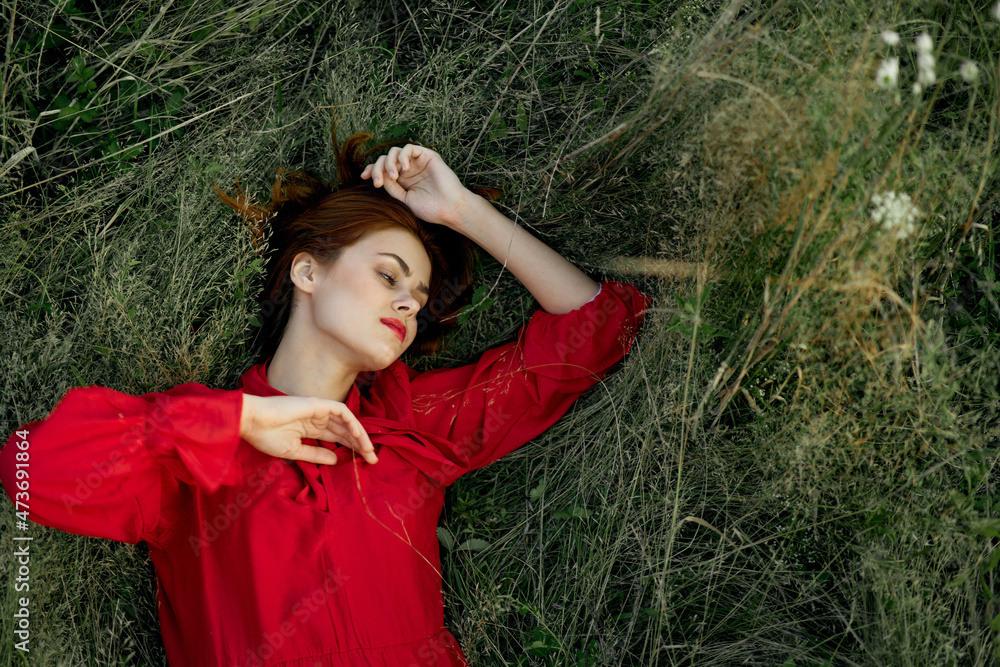 woman in red dress lies on the grass nature freedom summer woman in red dress lies on the grass nature freedom summer