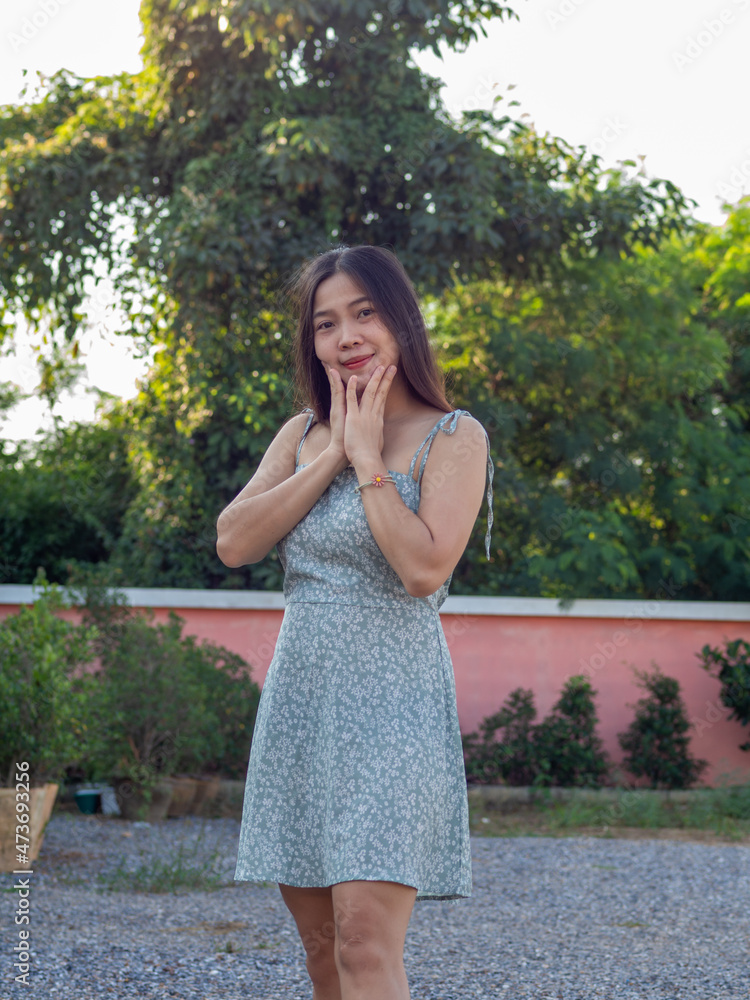 Naklejka premium a Asian nationality Thai woman wearing blue dress and feel good