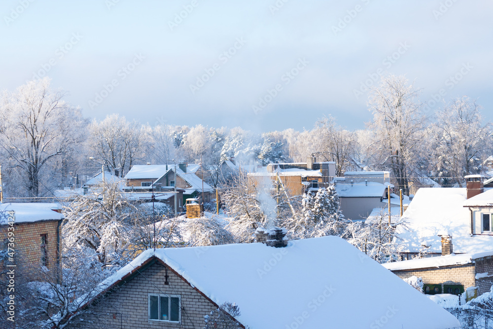 Small village in winter day, roofs with deep snow