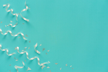 close up on group of white color of rolling ribbon and confetti on teal background with copy space for happy new year ,carnival , birthday and anniversary, concept design