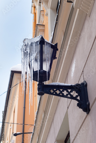 Old street lamp with icicles in cold winter day