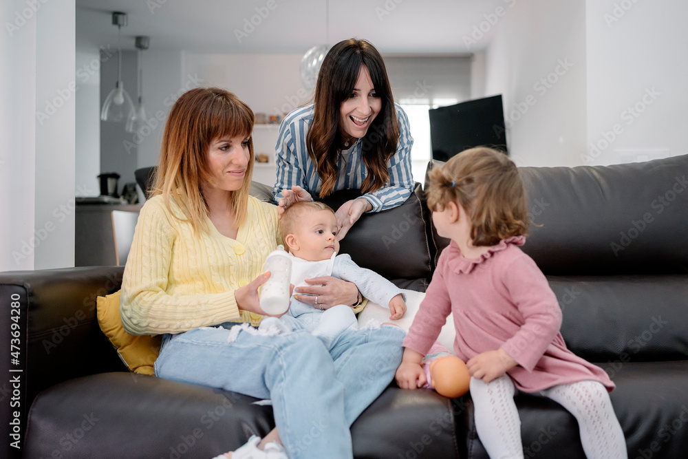 A Mom holding her baby while talk with their daughter A Mom holding her baby while talk with their daughter