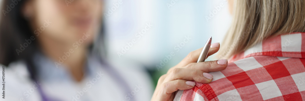 Female doctor put hand sympathetically on the patient shoulder closeup