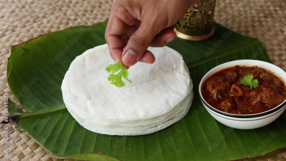 Rice Pathiri pathir flat bread spicy chicken curry woman hand serving ...