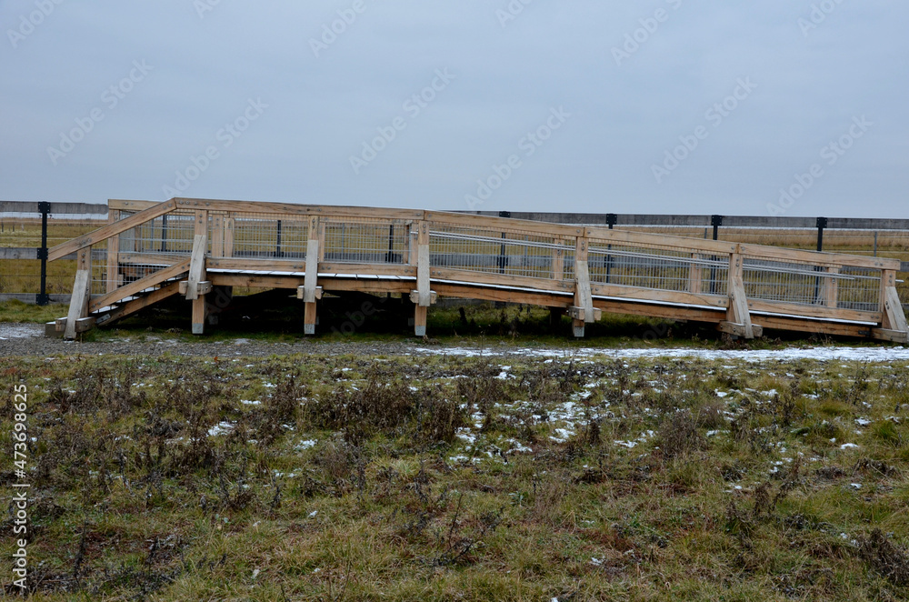 platform of a lookout tower made of oak logs and planks with barrier-free access for seniors and the immobile. wheelchair ramp. metal railings of stainless steel polished tube