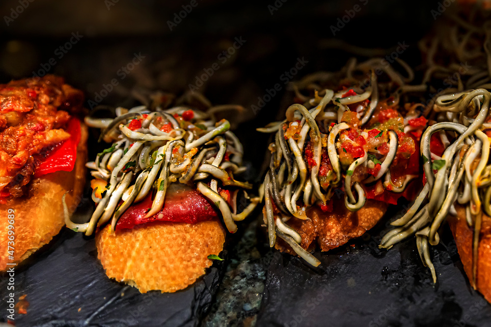 Fototapeta premium Spanish pintxos baby eel or angulas and ham in a Basque bar, San Sebastian Spain