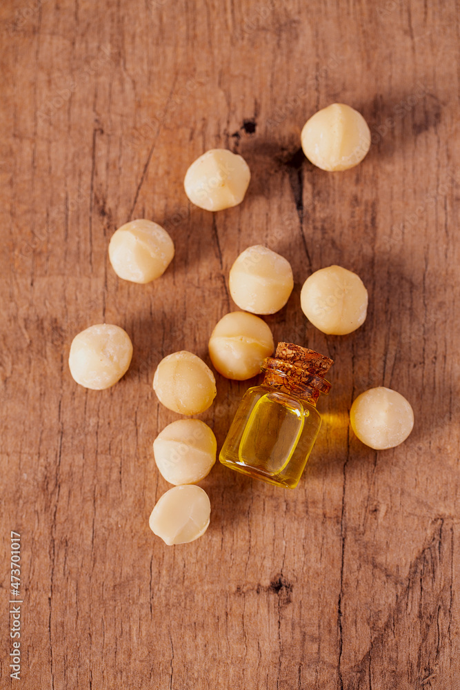 macadamian nut oil on dark wooden surface macadamian nut oil on dark wooden surface