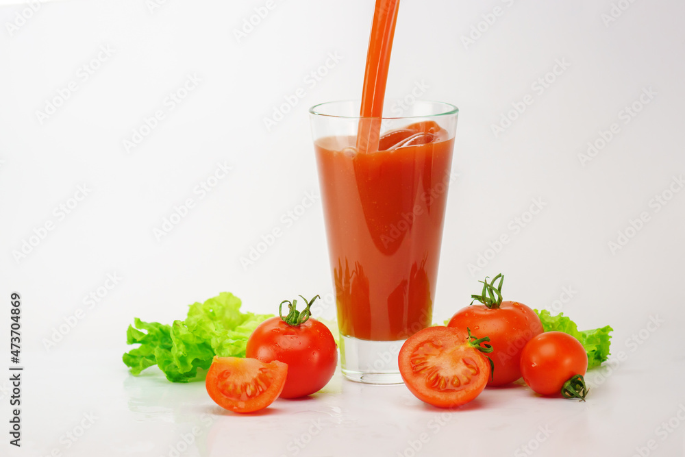 Glass of tomato fresh juice with raw tomatoes on light background Glass of tomato fresh juice with raw tomatoes on light background