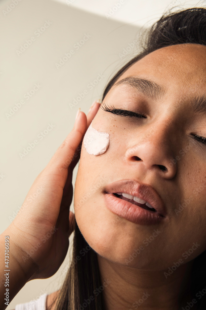 Beautiful filipino model applying skincare Beautiful filipino model applying skincare
