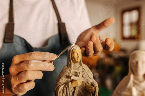 Crop artisan working with clay virgins in workshop