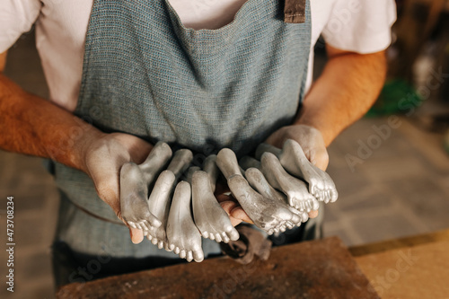 Crop artisan working with metallic foot pieces photo