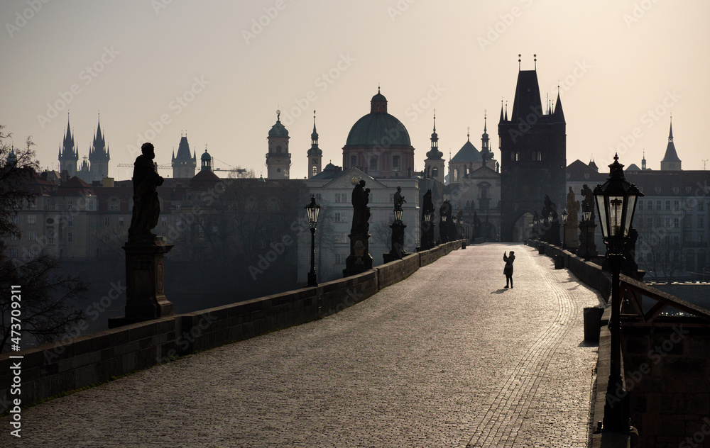 A tourist takes a photo on an empty bridge in Prague. A tourist takes a photo on an empty bridge in Prague.