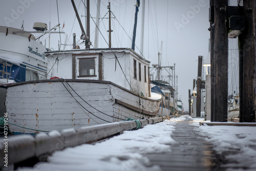 White boat on a snowy winter dock in British Columbia